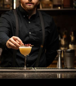 bartender garnishing a cocktail at the bar