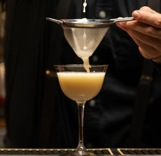 close up shot of bartender preparing a cocktail at the bar